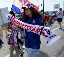 A student holds up a scarf reading, "Hrvatska," or Croatia